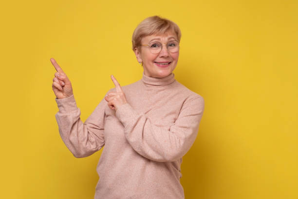 istock Happy mature lady looking at camera advertising product. 1301598563