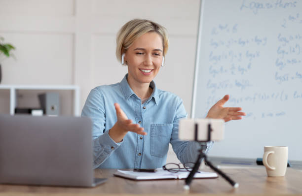 istock Distance learning and online tutoring. Confident teacher giving online math class, explaining logarithms on smartphone 1301600103