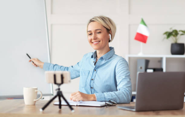 istock Professional teacher pointing at empty blackboard, giving online lecture or webinar, copy space 1301600115
