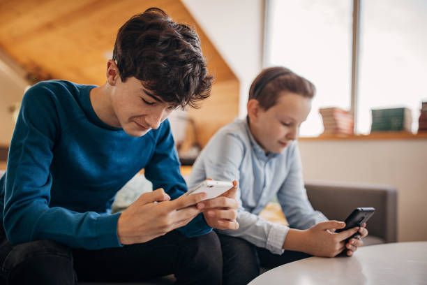 istock Twp boys using smart phones at home 1301600680