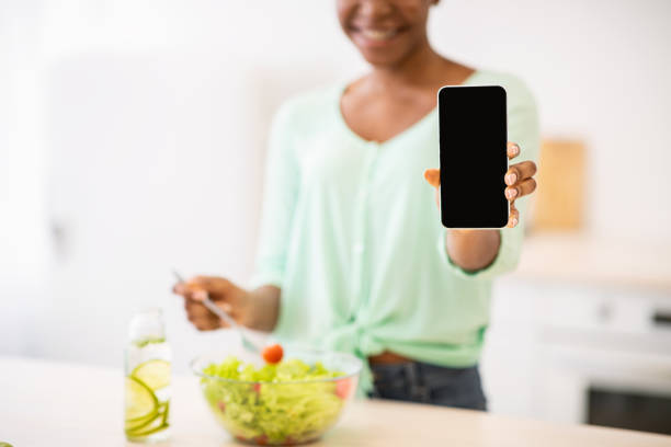 istock Black Lady Showing Phone Screen Recommending Weight-Loss App In Kitchen 1301601207