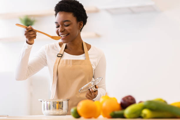 istock Black Lady Tasting Dinner In Kitchen Cooking Food At Home 1301601282