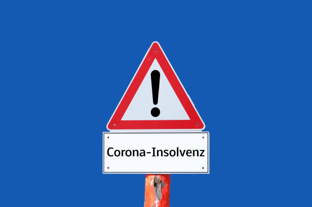 istock Caution warning sign Corona bankruptcy on blue background in german 1301601401