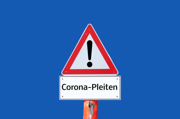 istock Caution warning sign Corona bankruptcies on blue background in german 1301601409