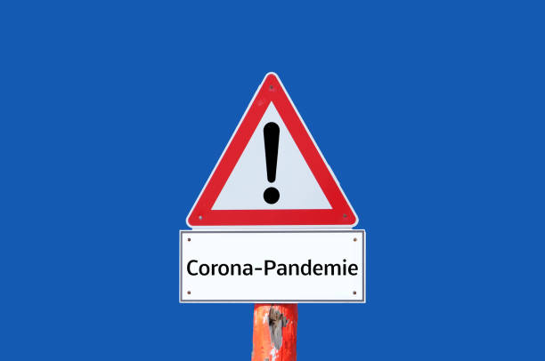 istock Caution Corona Pandemic Warning Sign on blue background in german 1301601423