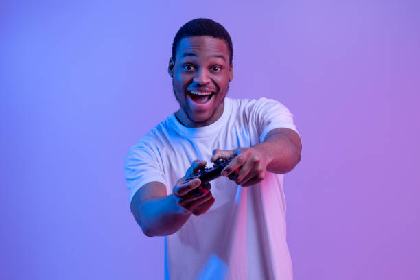 istock Overjoyed Black Gamer Man With Joystick Playing Video Games In Neon Lighting 1301602214