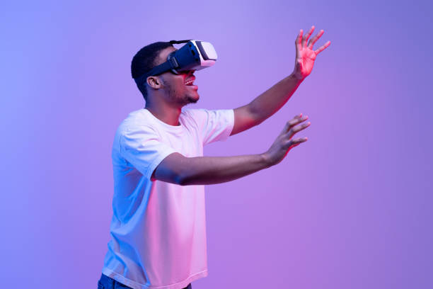 istock VR Technology. Excited african guy wearing virtual reality headset, vivid neon background 1301602285