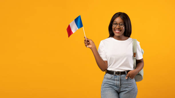 istock Positive black woman student with backpack holding french flag 1301603442