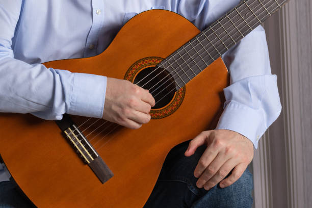 istock man is holding a guitar 1301604195