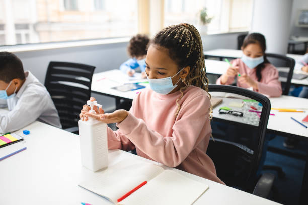 istock Small black girl applying antibacterial sanitizer on hands 1301604979