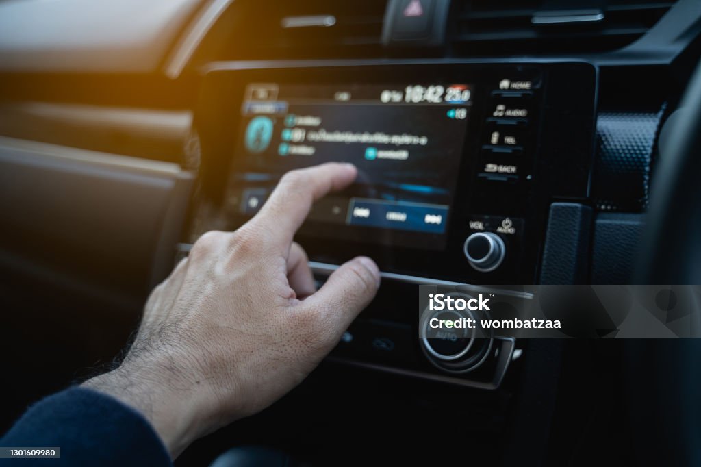 the driver using touch screen monitor in the modern car Radio Stock Photo