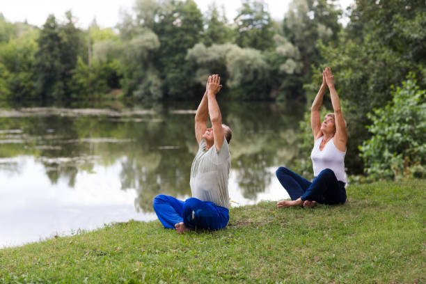 casal de família sênior se exercitando e fazendo seus alongamentos ao ar livre. estilo de vida saudável. distanciamento social. copiar espaço. - middle human age couple women - fotografias e filmes do acervo