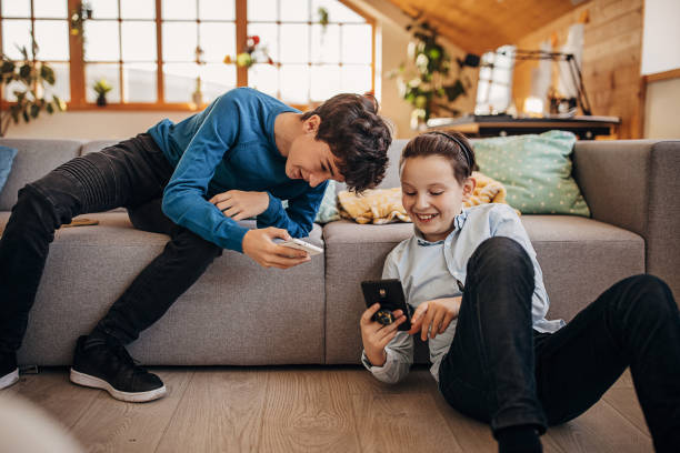 istock Two boys using smart phones at home 1301617052