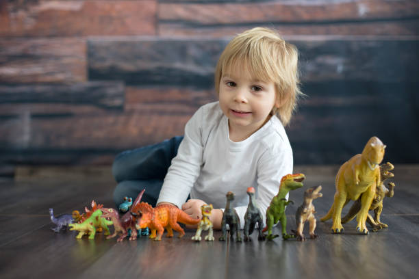 istock Blond toddler child, playing with dinosaurs at home 1301618139