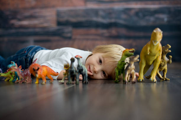istock Blond toddler child, playing with dinosaurs at home 1301618166