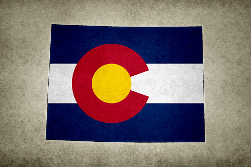 Grunge map of the state of Colorado (USA) with its flag printed within its border on an old paper.