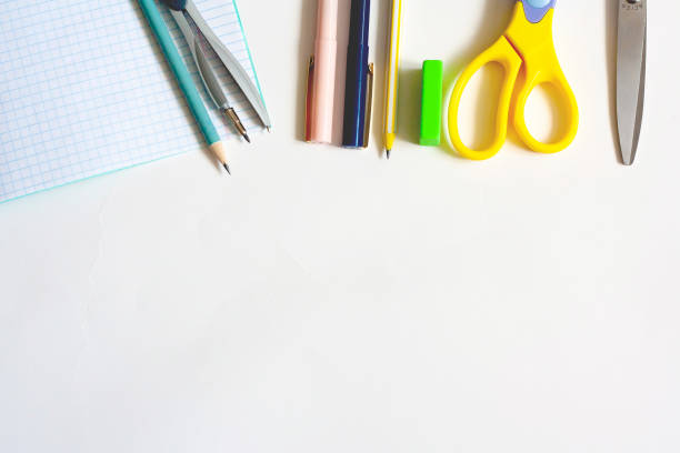 istock Stationery on a white background, notebook pens, pencils, compasses, eraser and scissors, flat lay, copy space 1301619561