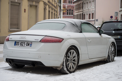 Mulhouse - France - 11 February 2021 - Rear view of white Audi tt convertible parked in the street covered by the snow