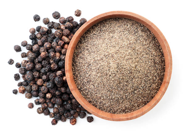 ground black pepper in a wooden bowl and peppercorns on a white background, isolated. top view - pepper imagens e fotografias de stock