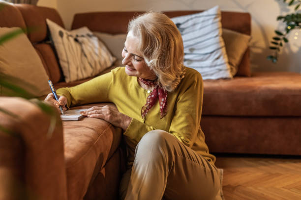 istock Senior woman at home, writing notes 1301623102