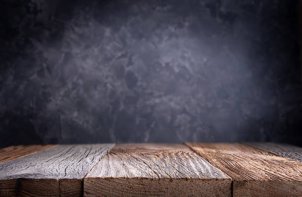 istock Empty wood table top with defocused concrete wall background. 1301623673