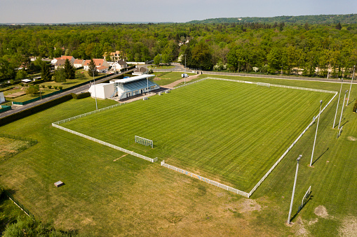 Corner point and red corner flag top view in soccer field. Green football carpet field. Drone shot.