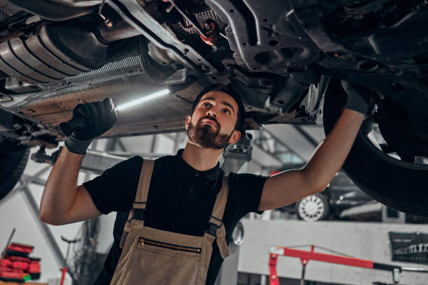 istock Professional auto mechanic working on the undercarriage of a car. 1301626867