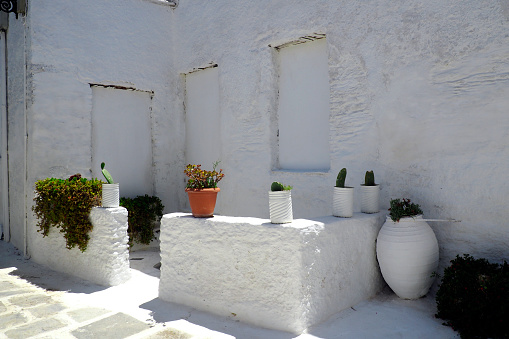 One of the charms of the Greek Cycladic Islands, in the heart of the Aegean Sea are the narrow streets: white houses, small flowered balconies and cobbled stairs.