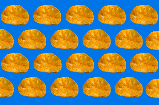 Rows of barbecue flavor potato chips on blue background