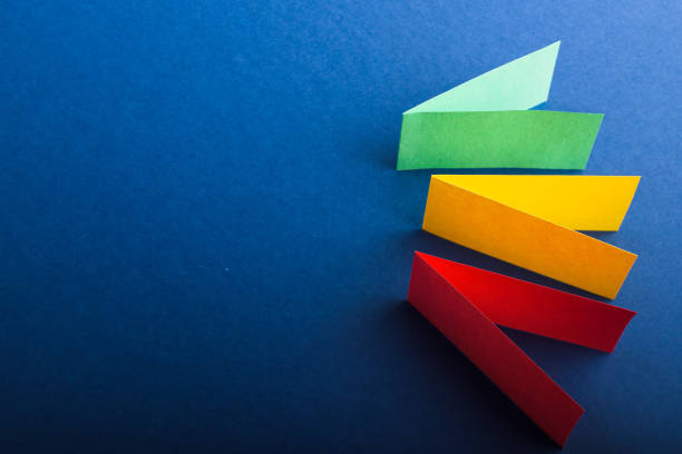 istock Multicolored cut paper on blue. Abstract arrows, direction signs. 1301629651