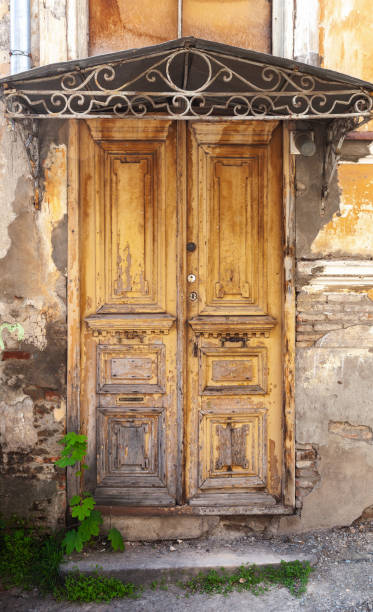 istock Vintage weathered wooden door under forged visor 1301630997