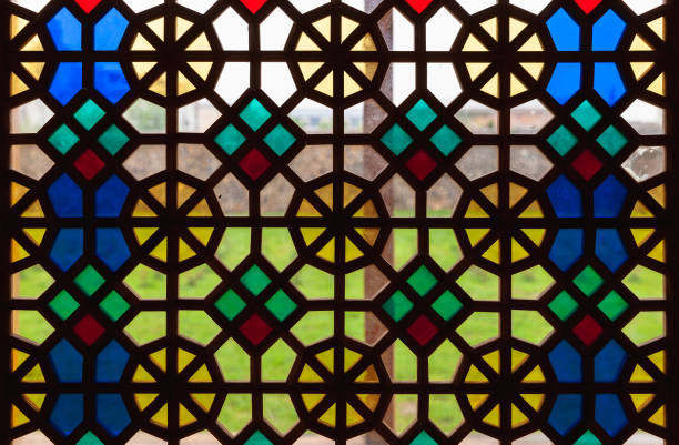 Details of bright and colorful old stained glass window in historic mayor's office in French town hall of Ambronay, also called Blains castle. Beautiful coats of arms dating back to the 16th century, illuminated by the exterior light of the sun. Photo taken in Ambronay, in Ain department, in Auvergne-Rhone-Alpes region in France.