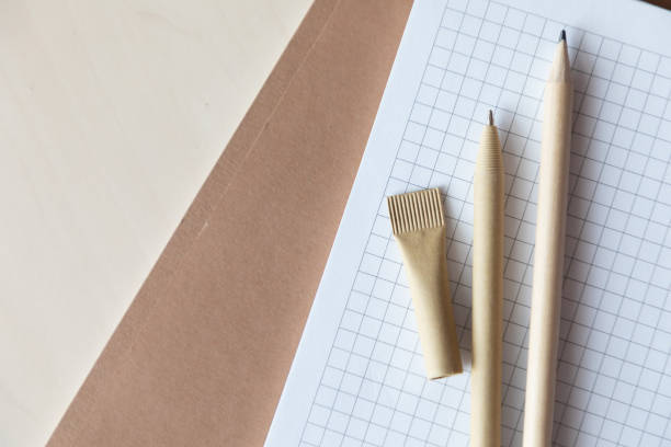 istock Reusable eco-friendly craft paper pen and pencil on notebook. Writing ballpoint pen, environmental protection, ecology, natural materials, recycling concept 1301632212