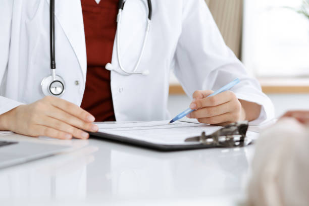 istock Unknown woman-doctor consulting patient and using clipboard with a medication history record. Medicine concept 1301632335