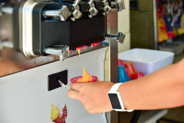 la mano della ragazza prende il gelato in una tazza dalla macchina - ice machine foto e immagini stock