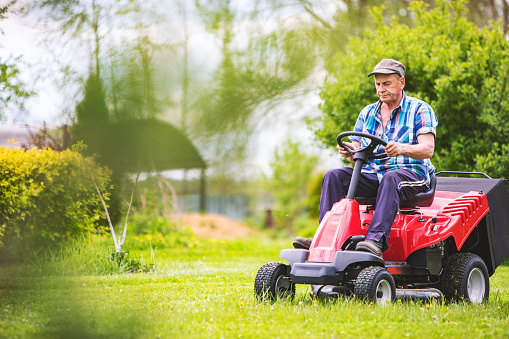 A man works the land in the garden with a cultivator, prepares the soil for sowing. farming concept