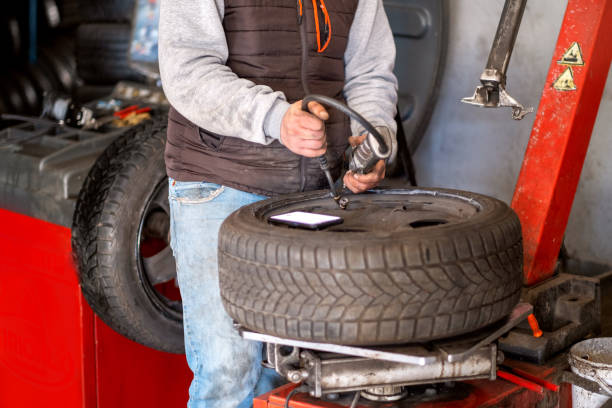 istock Technician car tire inflation with inflator. 1301636726