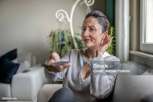 Young Adult Woman With Hearing Aid Watching Television Stock Photo - Download Image Now