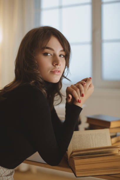 istock Young Woman Reading a Book at Home 1301636828