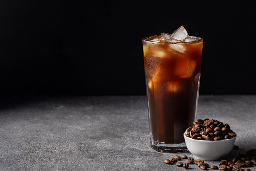 cold iced coffee on a dark background coffee beans, summer drink
