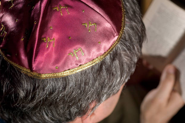 Jewish man wearing Kippah skull cap, and making his prayers on the Siddur, book of prayers.