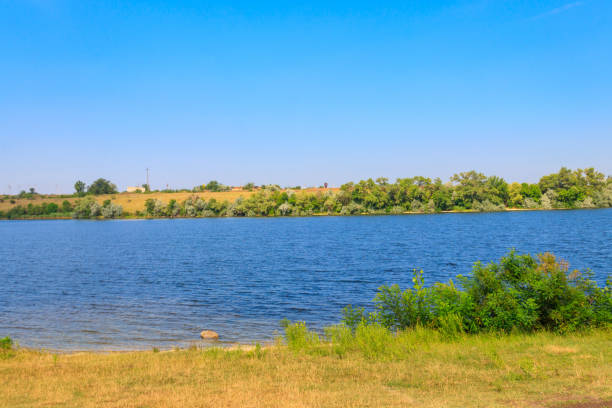 istock Summer landscape with beautiful river, green trees and blue sky 1301639339