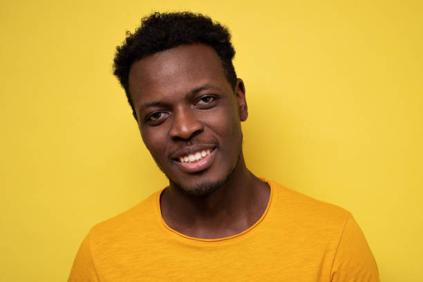 istock Smiling young african american man on yellow background 1301639349