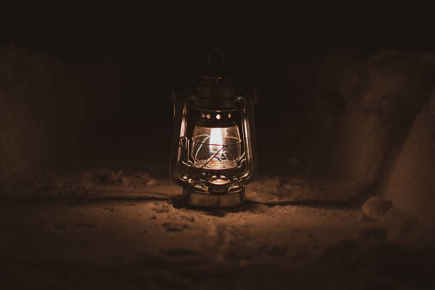 istock burning oil lamp stands on a snowy path at night 1301639401