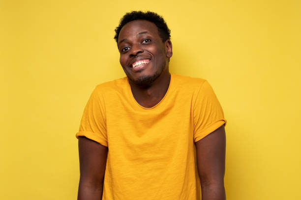 istock Smiling young african american man on yellow background 1301639471