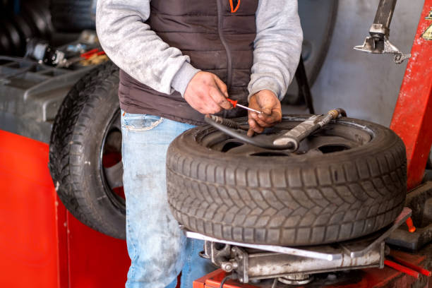 istock Technician car tire inflation with inflator. 1301639485