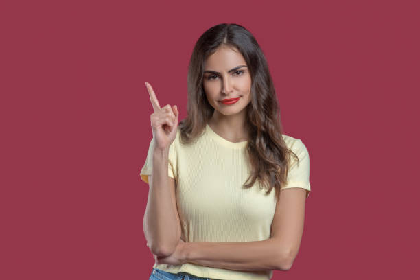 istock Convincing young woman with raised finger 1301640596