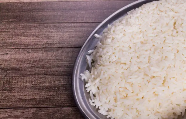 Photo of White rice served on a tray. Cooked rice popular food. Photo with food aligned to the right.