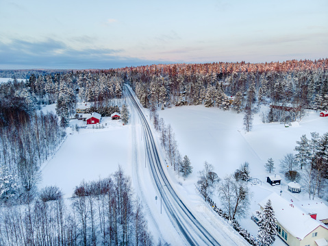 This image shows day time view Aerial view of the road in the winter snow forest in Finland, Lapland