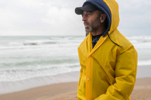 istock Man on the beach on a rainy day 1301644263